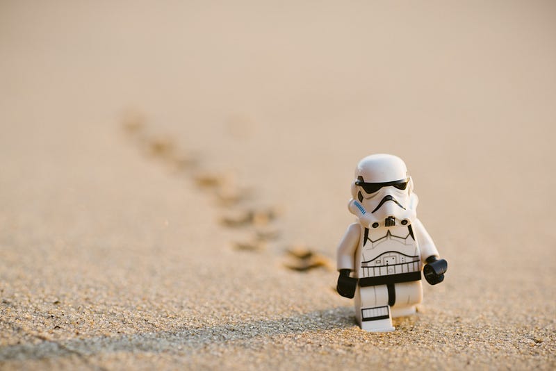 “A Lego stormtrooper on sand” by Daniel Cheung on Unsplash